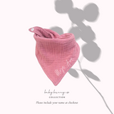 Baby cotton bib with button closure in pink.