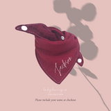 Baby cotton bib with button closure in burgundy.
