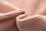 Close up of the knitted baby wrap texture in light pink.