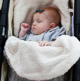 Baby in stroller laying on top of knit swaddle wrap in gray.  The swaddle is lined and for winter use.