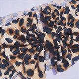 Close up of baby headband with bow in leopard print.
