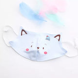 One light blue reusable childrens' face mask with a cute cat face printed on the mask.