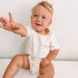 Unisex 2 piece cotton tee shirt and shorts set in white with mustard yellow trim.