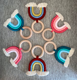 Handmade rainbow macrame wooden teether in various colours.