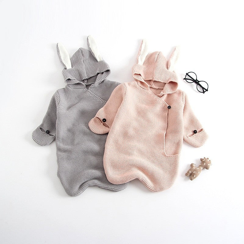 Gray and light pink knitted baby wraps with bunny ear hoods.