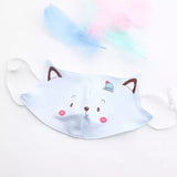 One light blue reusable childrens' face mask with a cute cat face printed on the mask.