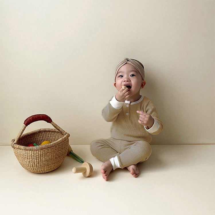Baby wearing 2 piece cotton long sleeve and pants set in tan.