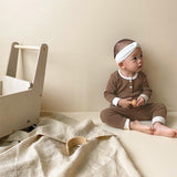 Baby wearing 2 piece cotton long sleeve and pants set in brown.