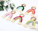 Handmade rainbow macrame wooden teether in various colours.